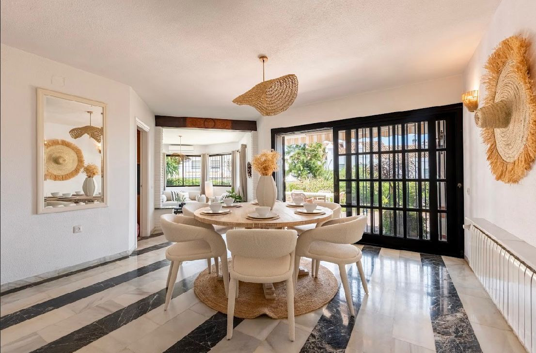 Bright dining area with round table, four chairs, and a large sliding door to the outside.