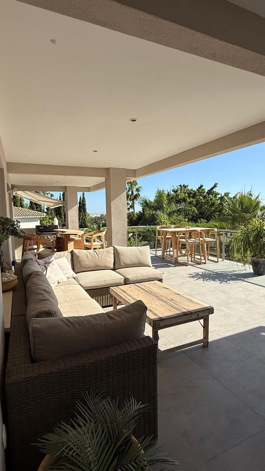 Spacious lounge area with sectional sofa and decorative plants.