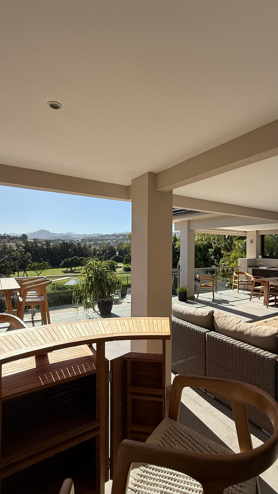 Open terrace view showcasing mountains and green landscape.