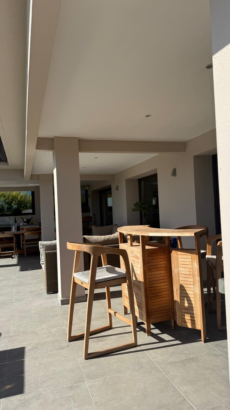 Covered terrace with a wooden bar and seating area.