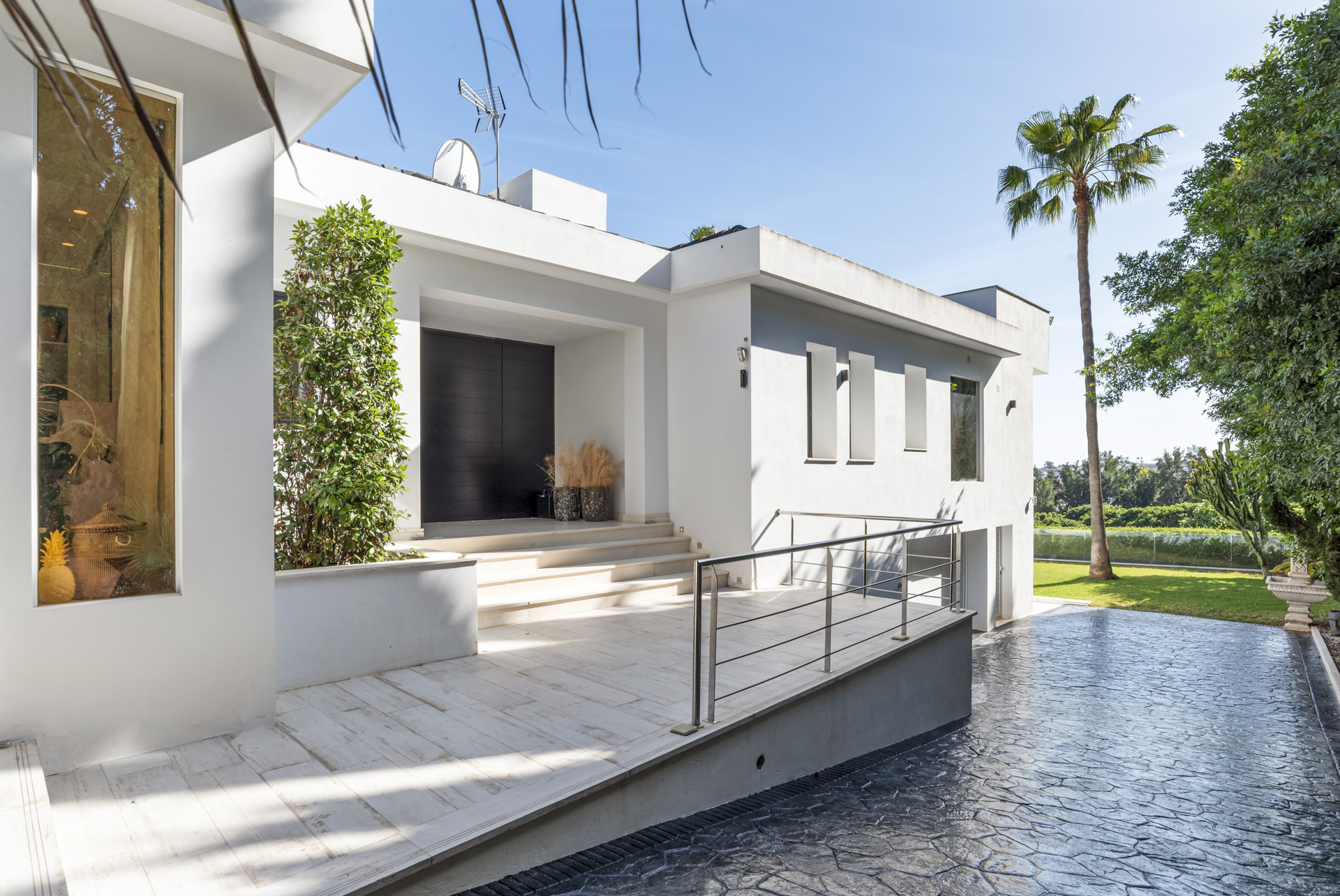 Modern exterior view featuring entrance steps and greenery.