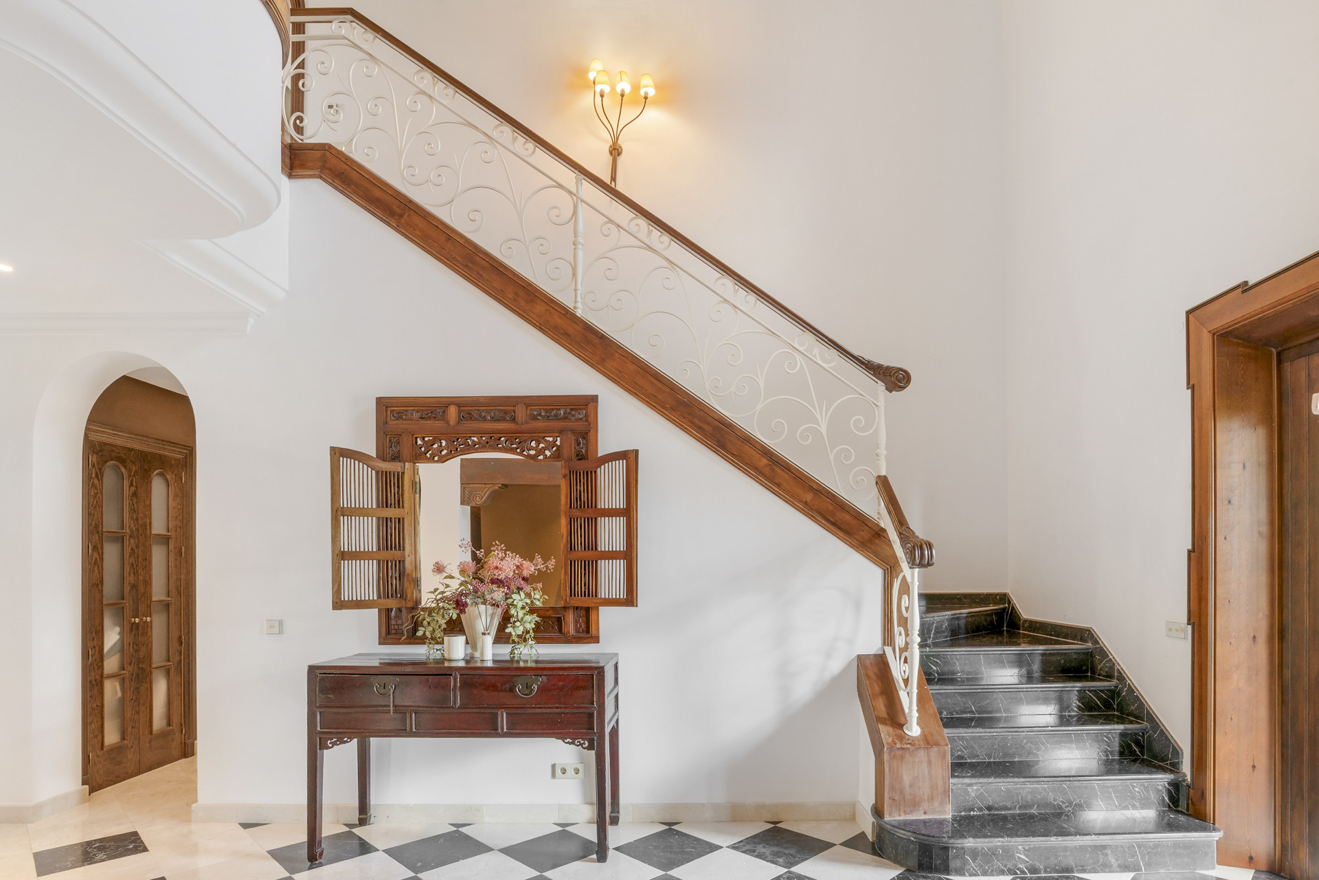 Stylish staircase and console table with flowers.