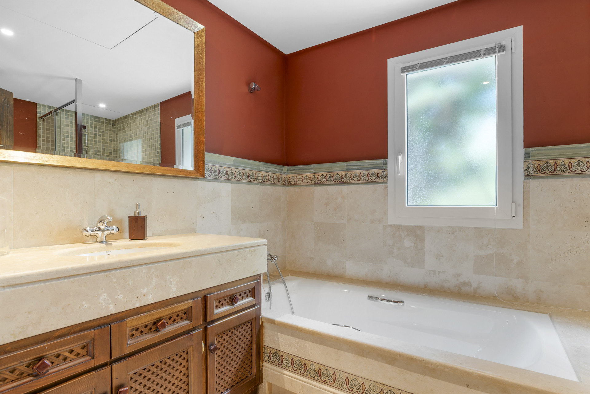 Elegant bathroom featuring a bathtub, marble countertop, and decorative tiles.