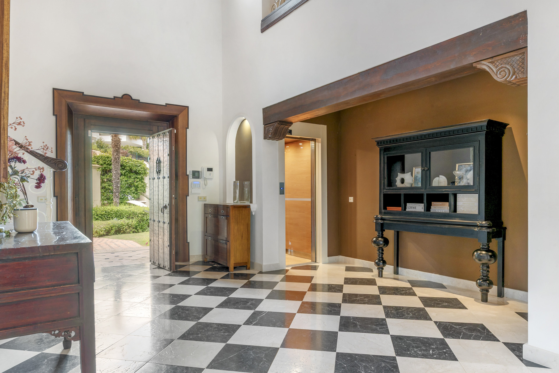 Bright entrance hall with black and white checkered floors.