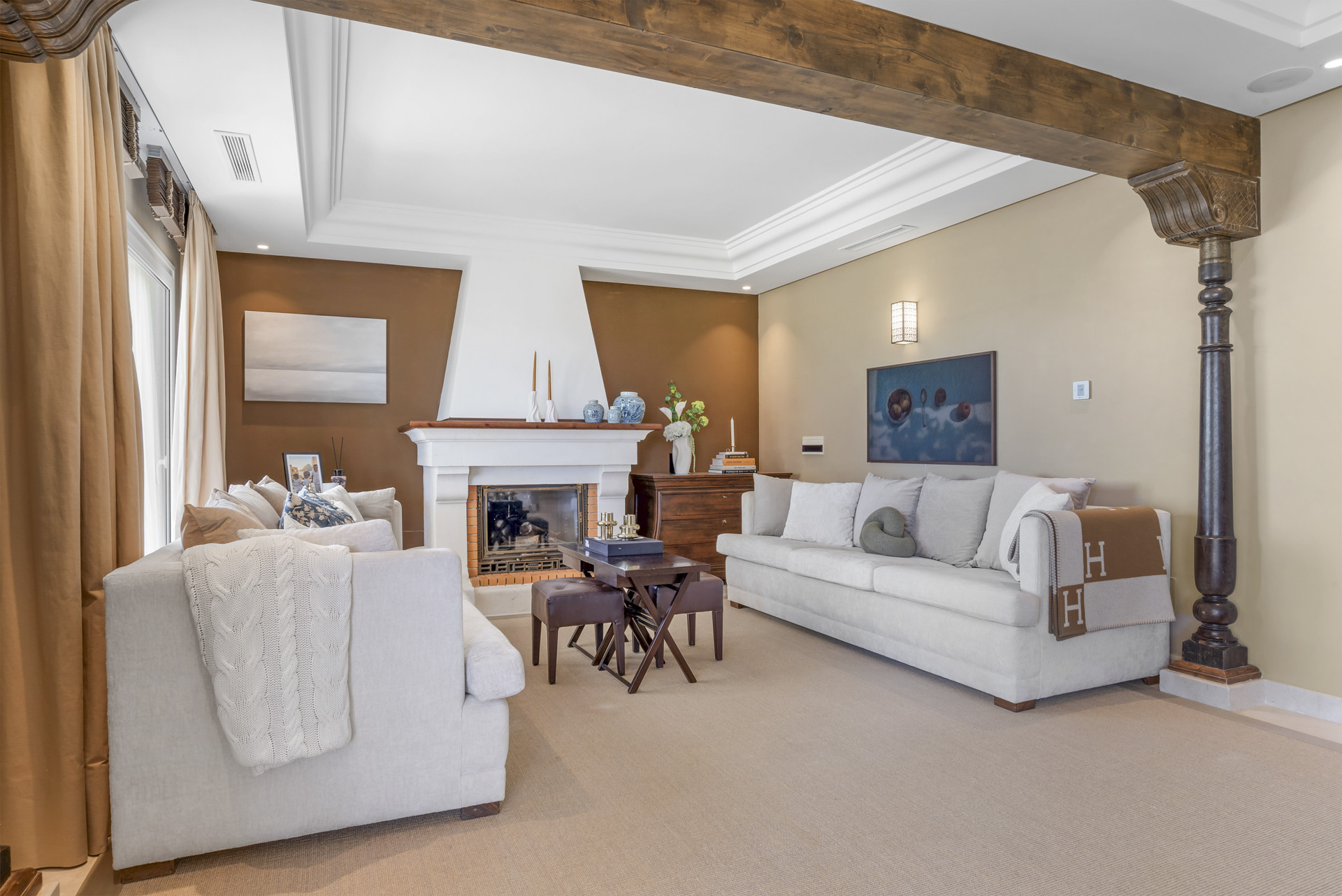 Cozy living room with fireplace, comfortable seating, and decorative art on the walls.