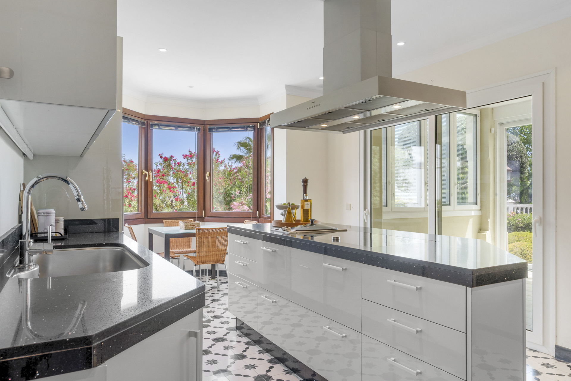 Spacious kitchen perspective showing dining area and large windows with garden views.