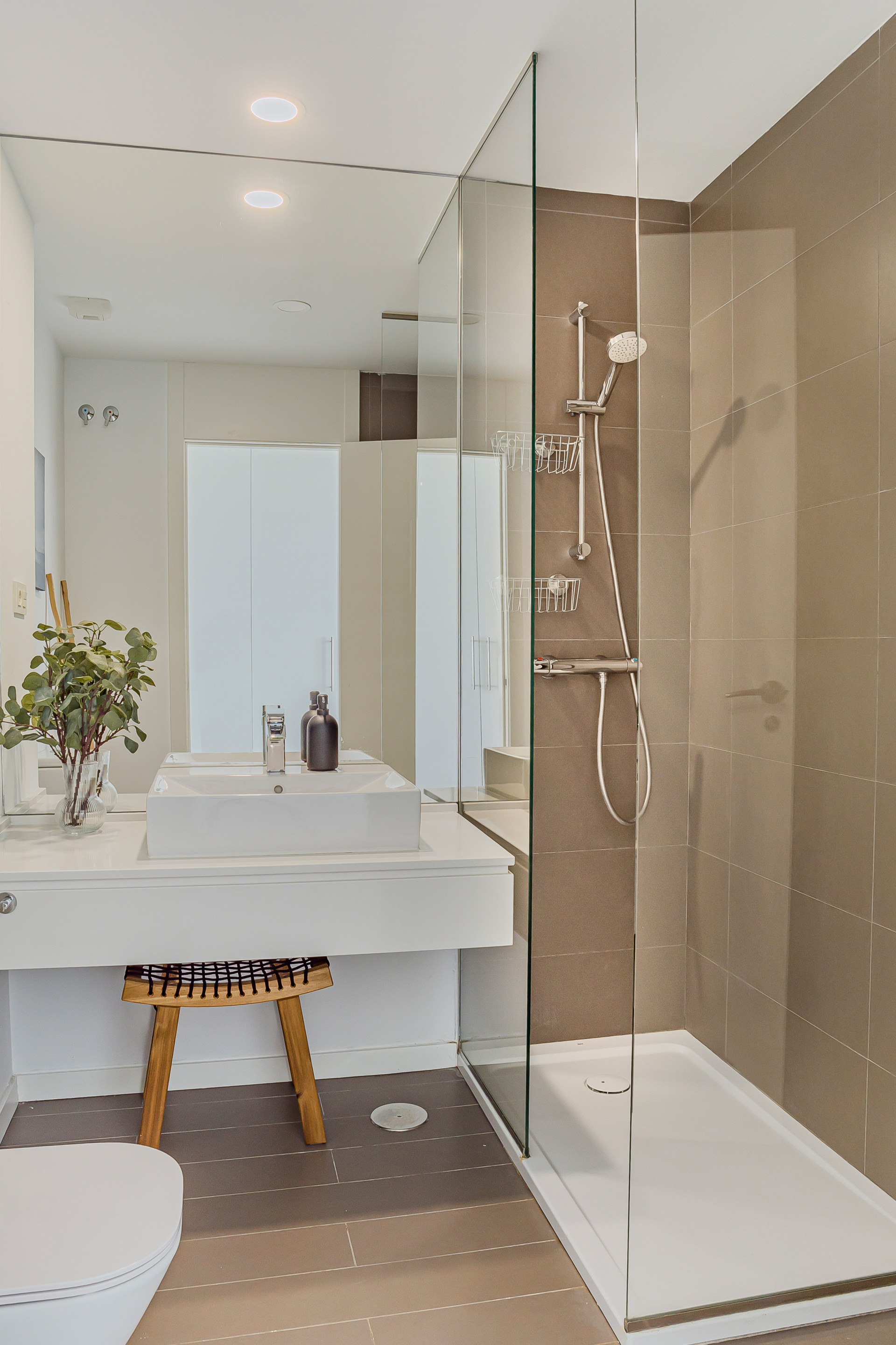 Bathroom with a walk-in shower, modern vanity, rectangular sink, and large mirror.