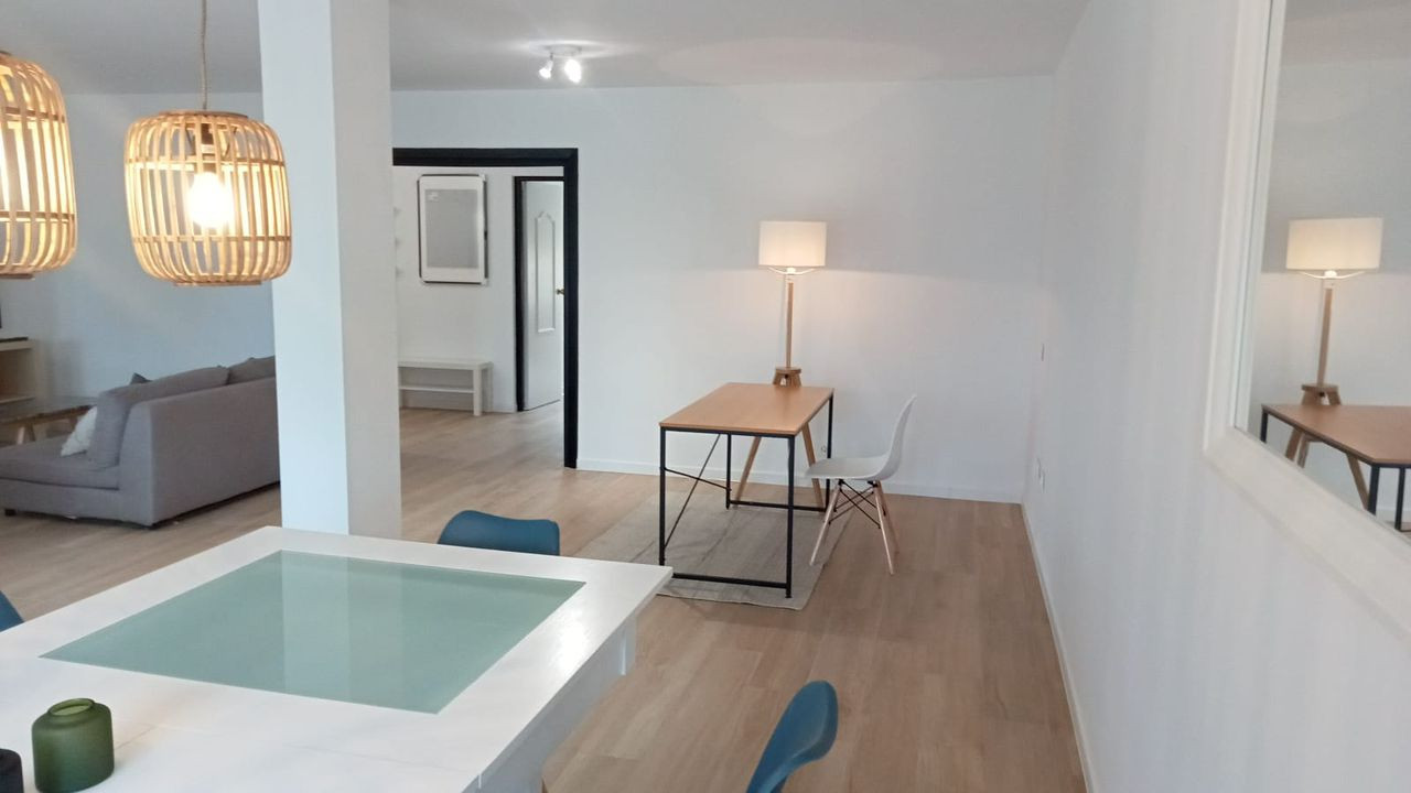 Dining area with a view into a separate study space and a hallway beyond.