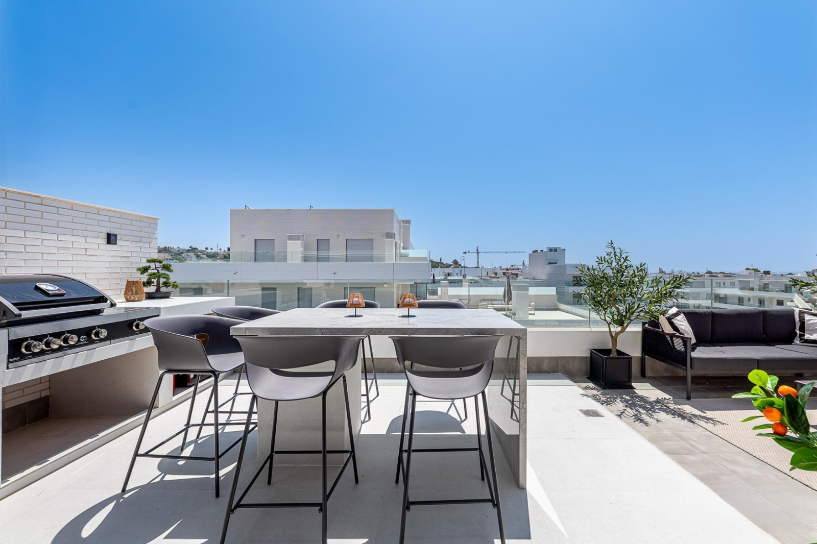 Rooftop terrace with outdoor kitchen, seating area, and panoramic city views.