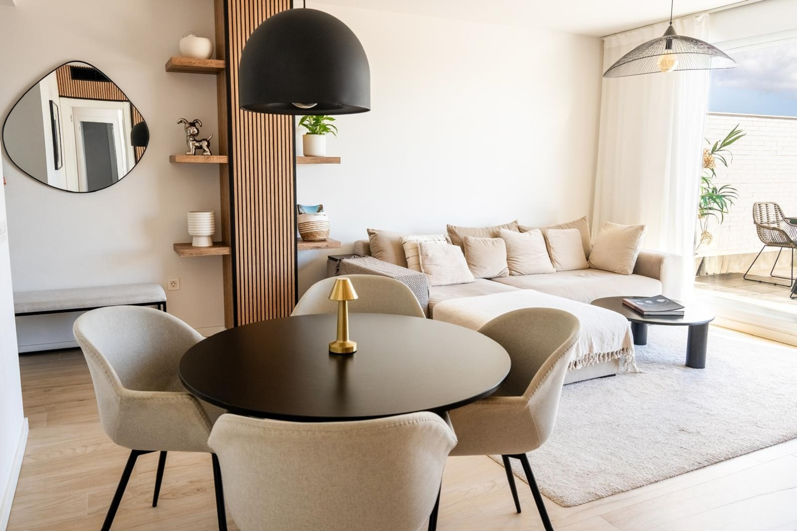 Open concept living and dining area with a round table, sofa, and access to an outdoor terrace.