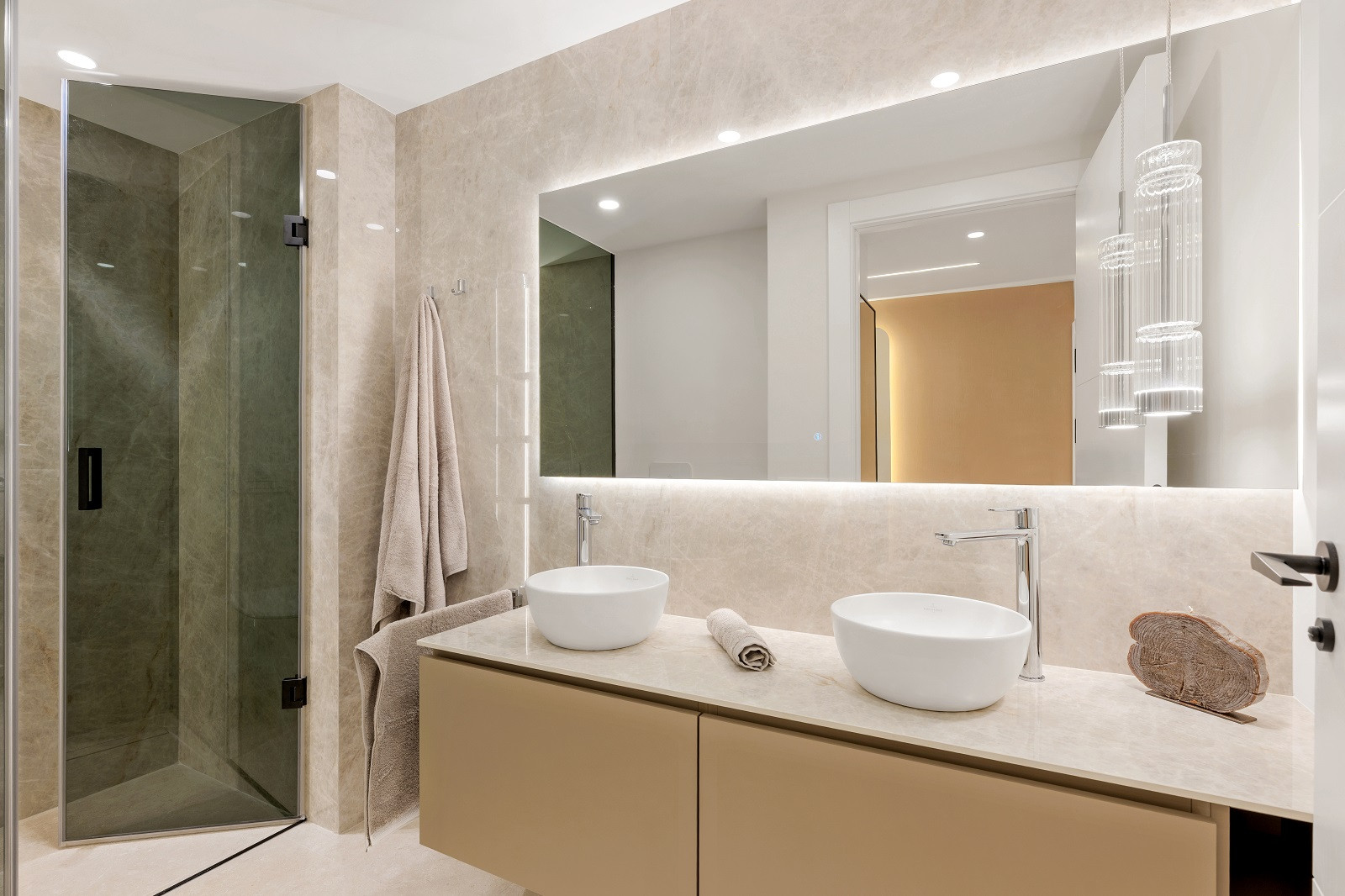 Bathroom with a double vanity featuring vessel sinks and a walk-in shower with a glass enclosure.
