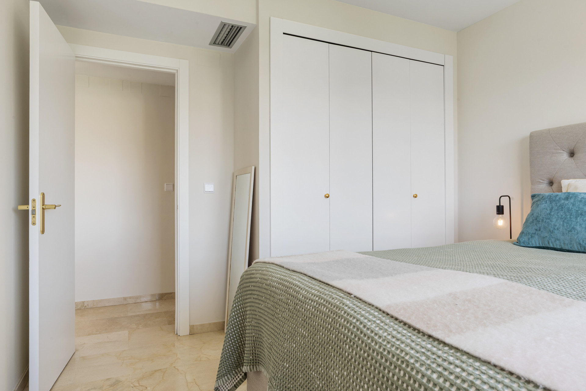 Bedroom perspective with a closet, open door, and a floor mirror