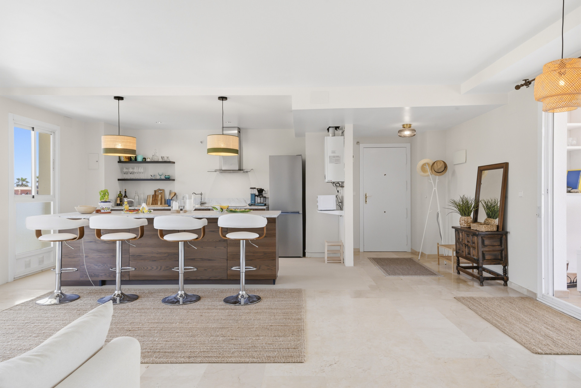 Modern kitchen with bar seating, pendant lights, and stainless appliances.