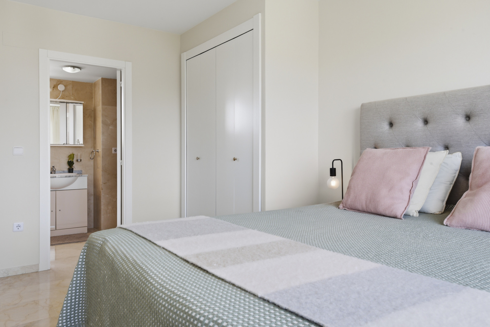 Bedroom view showcasing an entrance to a bathroom and a built-in wardrobe.