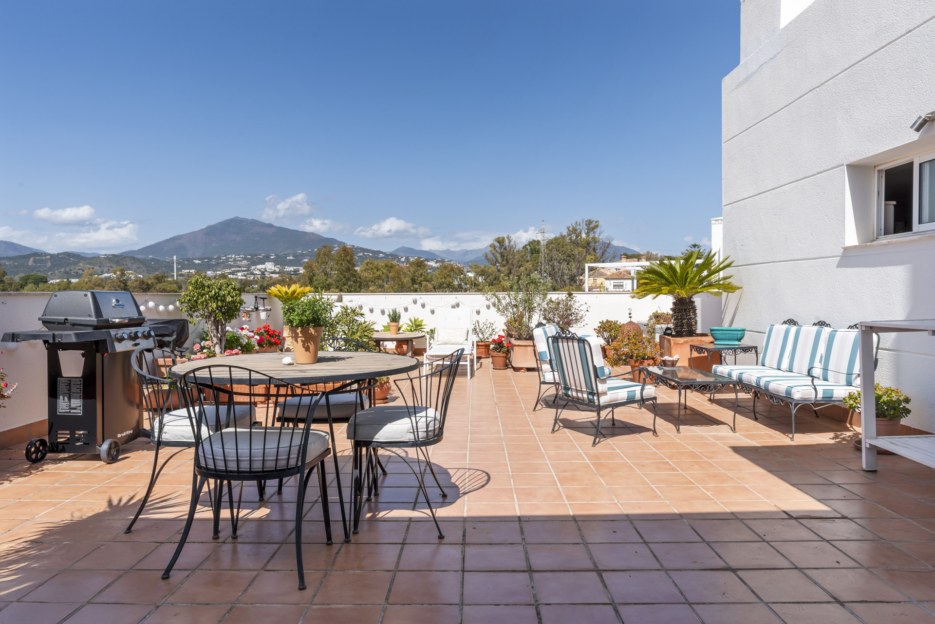 Outdoor terrace with dining set and barbecue grill.