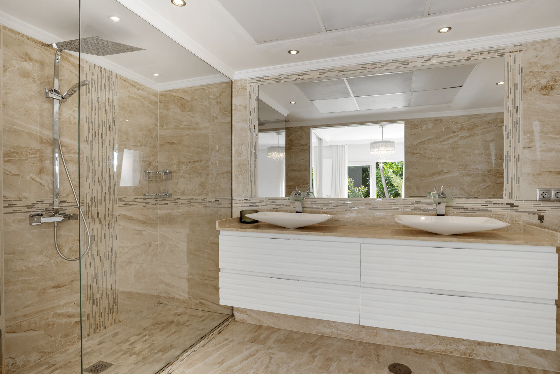 Bathroom with marble shower, dual basin vanity, large mirror, and recessed lighting.