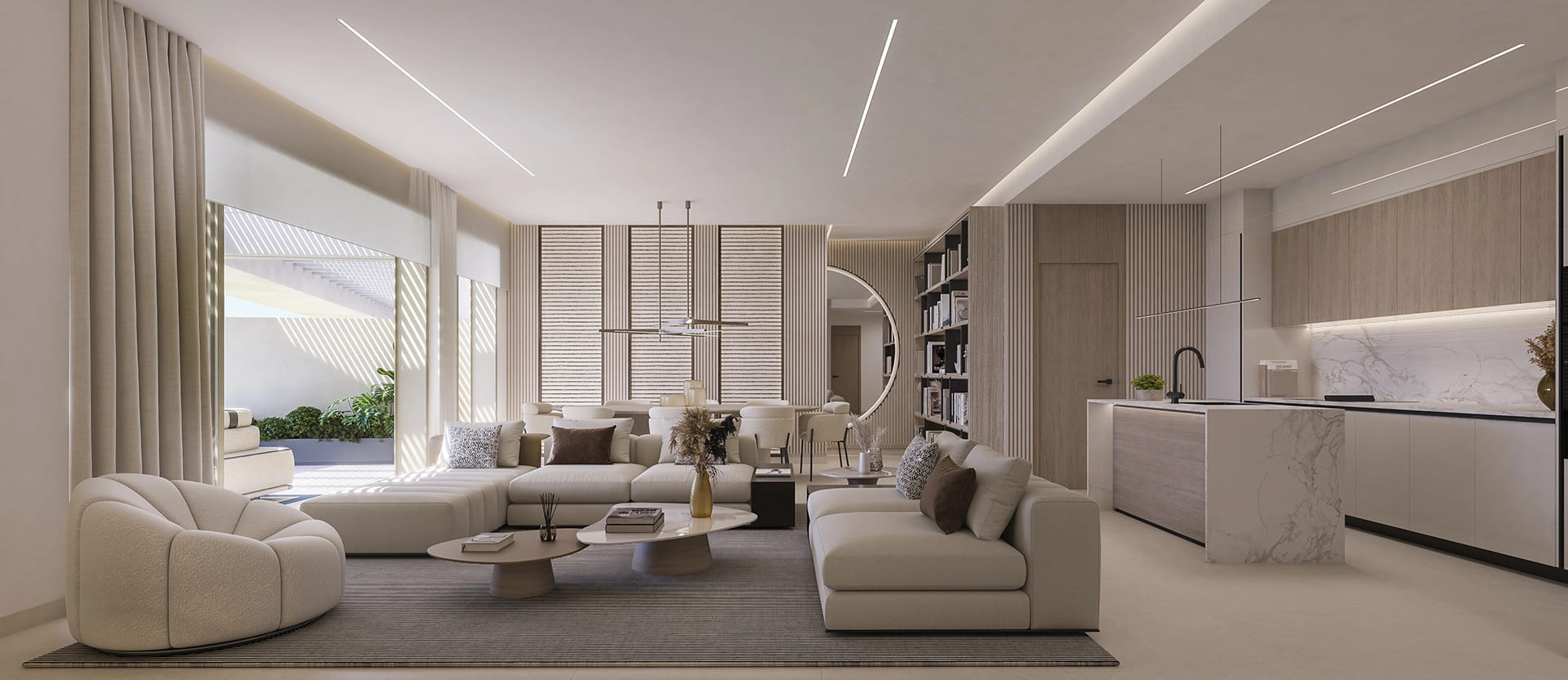 Open plan living room and kitchen with a large sectional sofa and circular mirror.