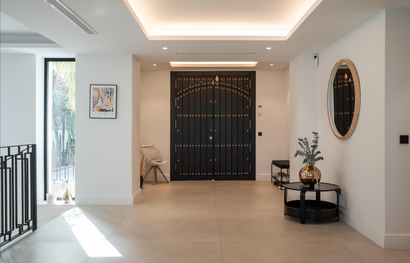 Modern entryway with large black double doors and side mirrors.