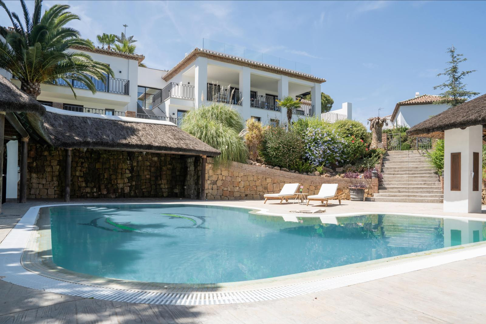 View of the pool from the side showcasing the villa and stairs.
