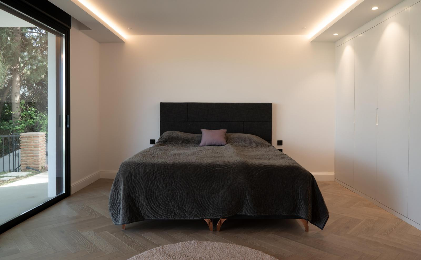 Bright bedroom with a large bed, natural light, and a closet.