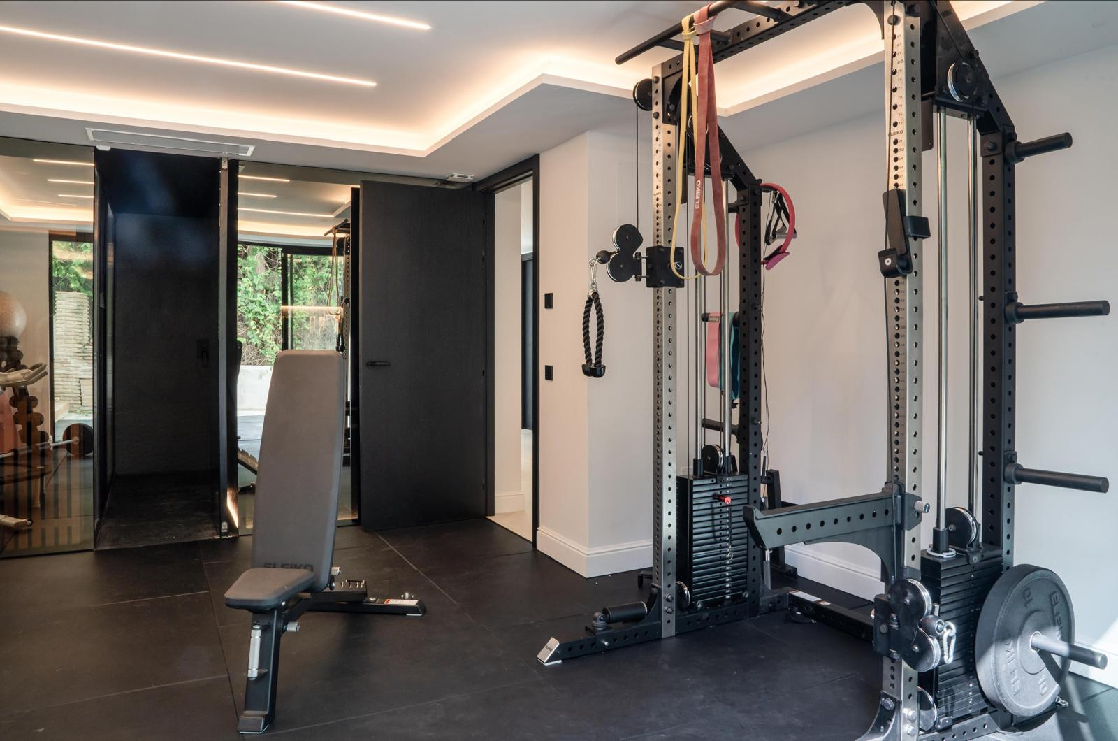 View of gym with exercise bench and mirrored storage door.