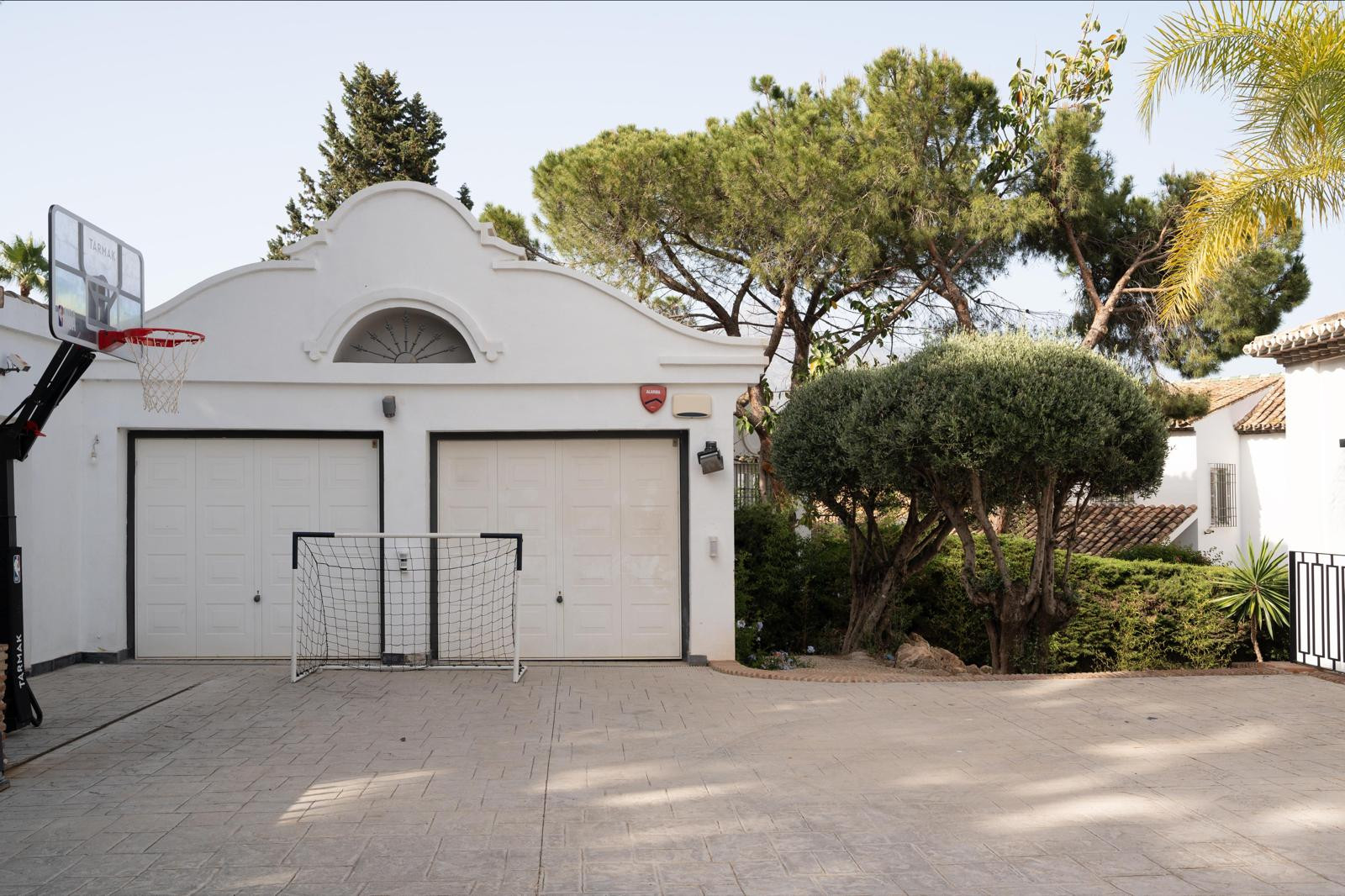 Garage area with two doors and a basketball hoop.