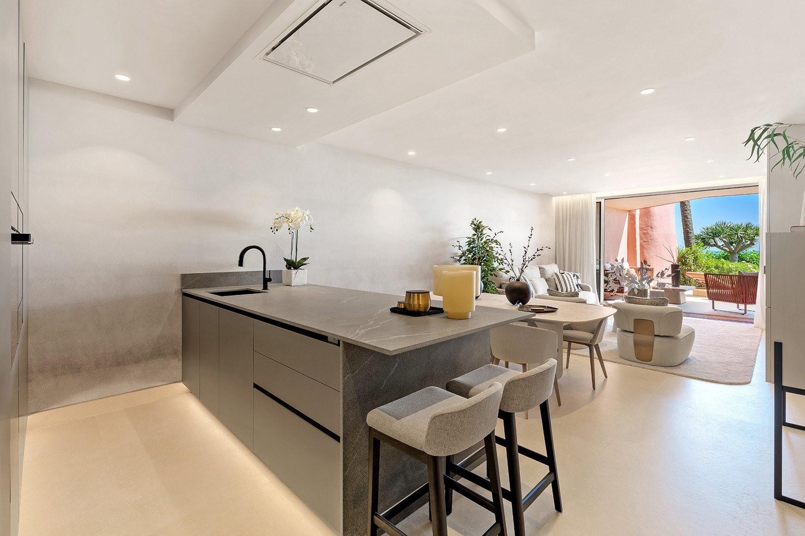 Modern kitchen island with bar seating, open concept living area, and sliding doors to a patio.