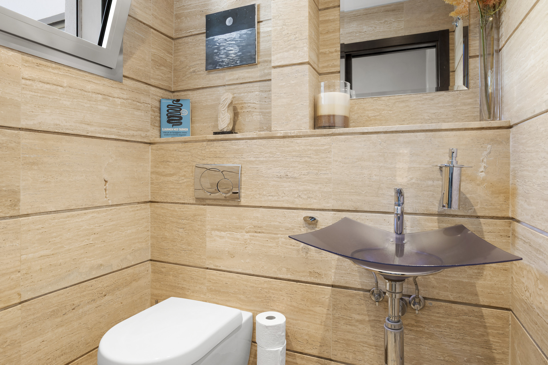 Powder room with light tiled walls, a modern toilet, and a unique glass sink.