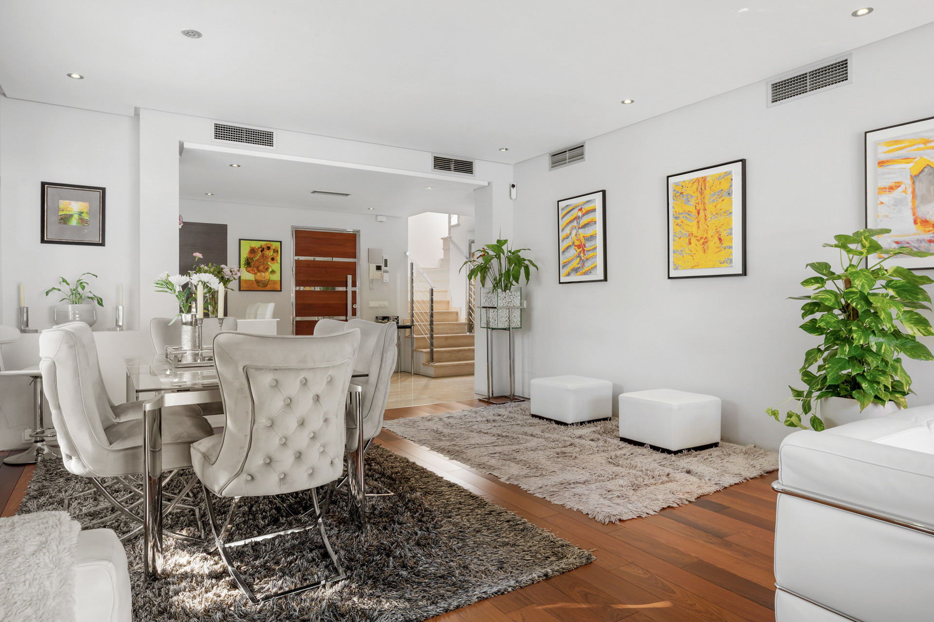 Dining area with a large table and tufted chairs, visible from the living room.