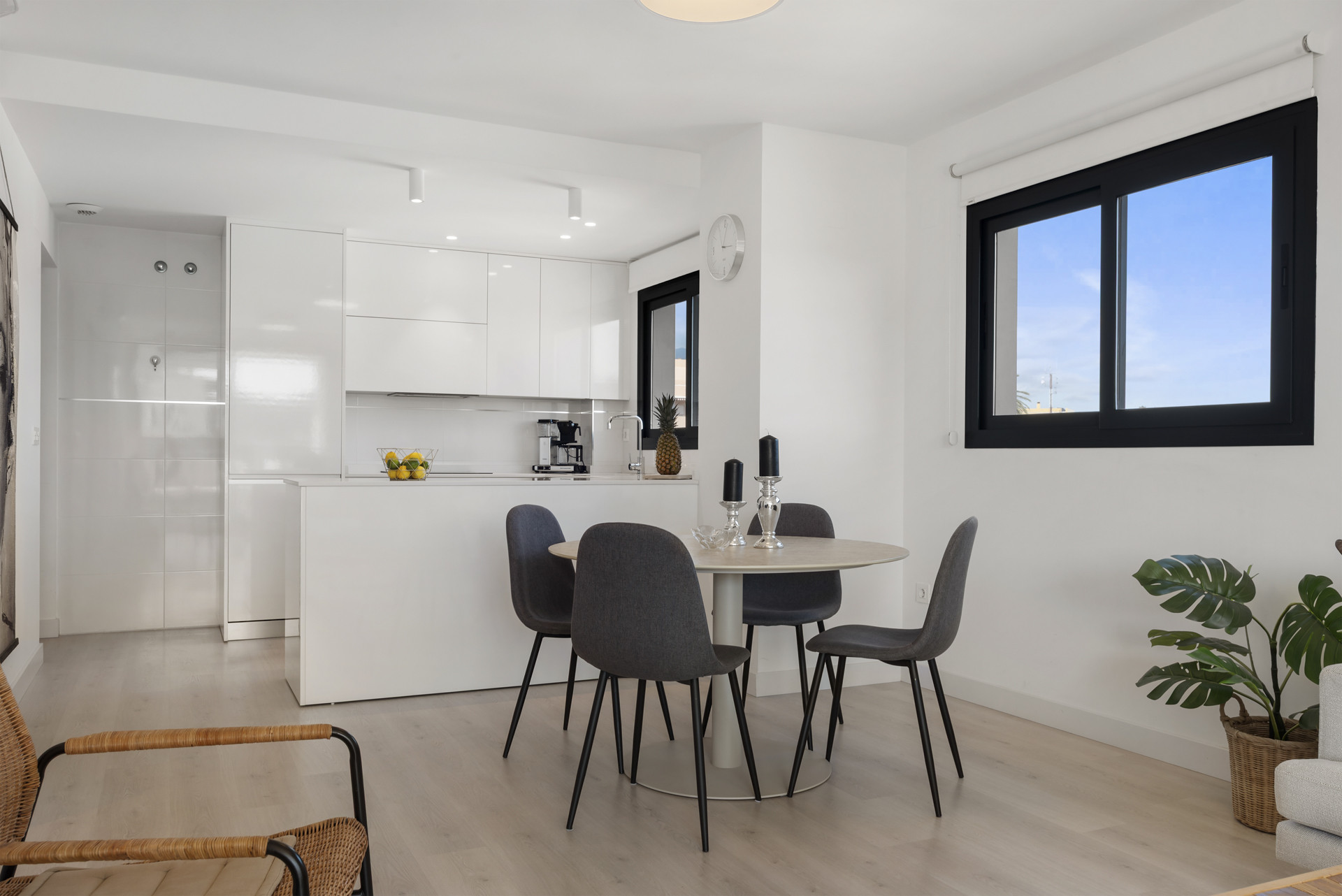 Open concept kitchen with a round dining table for four, and view of the living space.