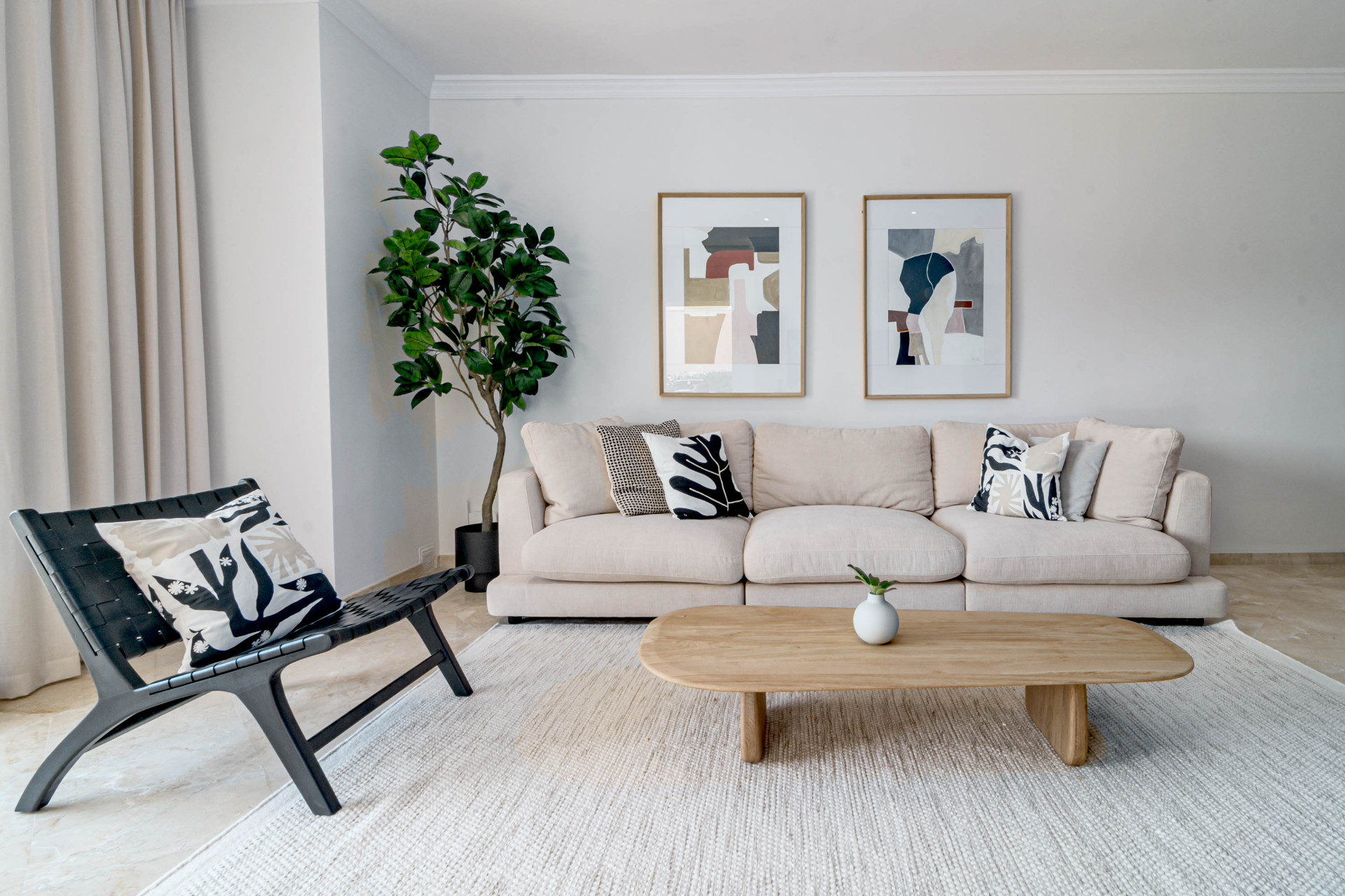 Close view of a modern living room with a large sofa, accent chair, and framed abstract art on the wall.