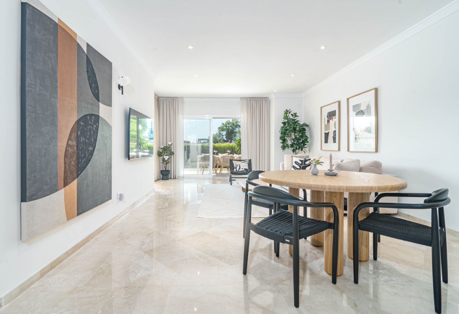 Open plan living area with dining table, large abstract art, and sliding doors to outdoor patio.