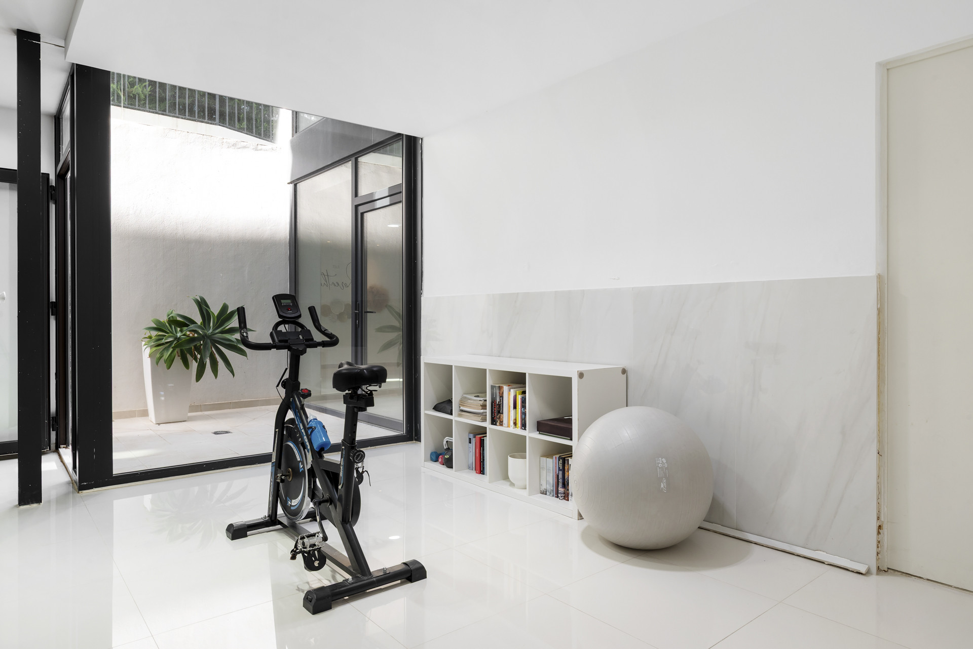 Home gym area with a stationary bike, exercise ball, and open space.