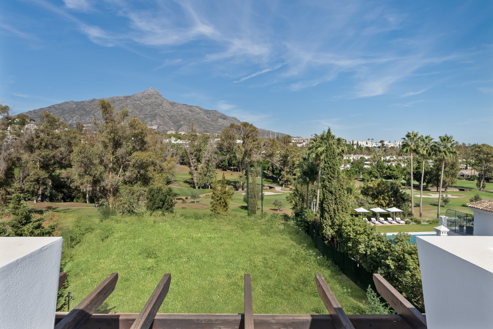 Landscape view from balcony overlooking golf course and mountains.