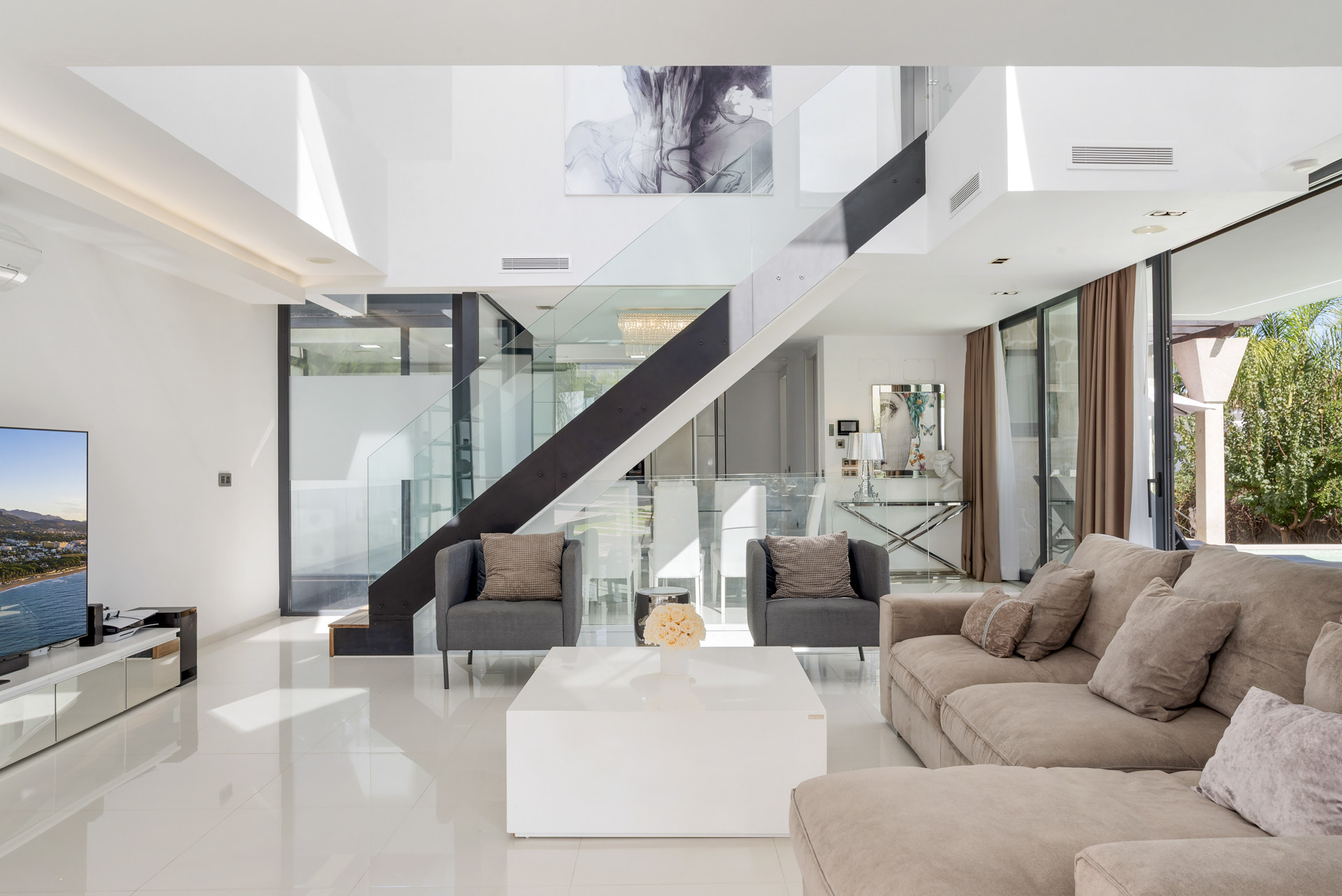 Living room featuring a glass staircase and minimalist design.