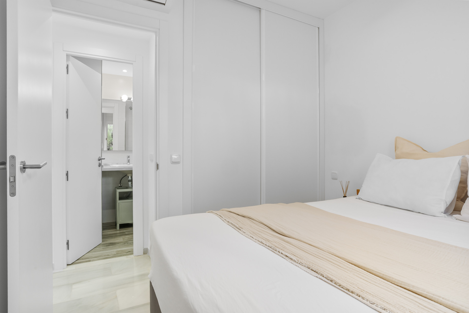 Angle showing a bedroom with an adjoining bathroom and closet doors.