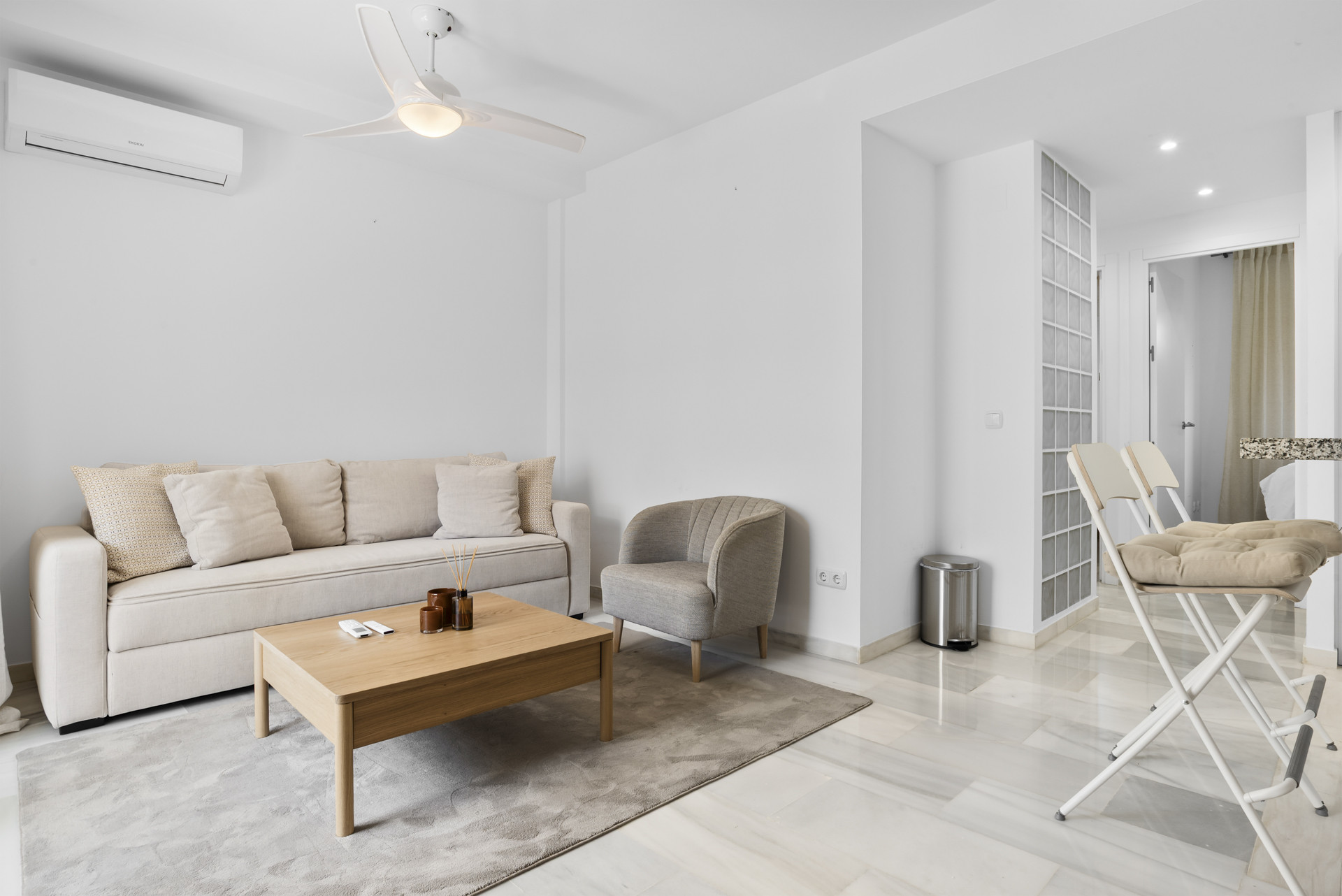 Living room featuring a light sofa, coffee table, and ceiling fan.