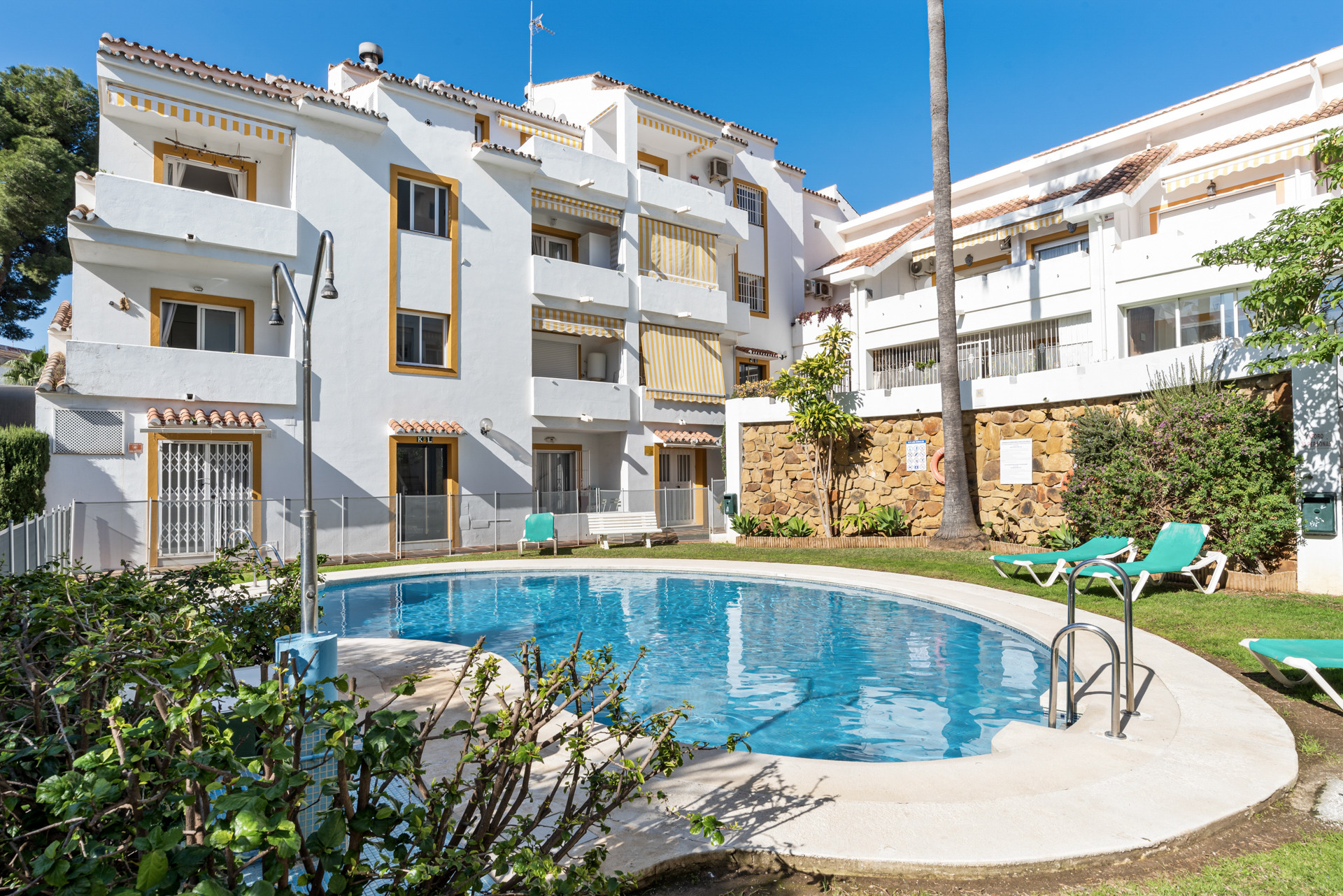 Outdoor view of a swimming pool surrounded by the apartment building.