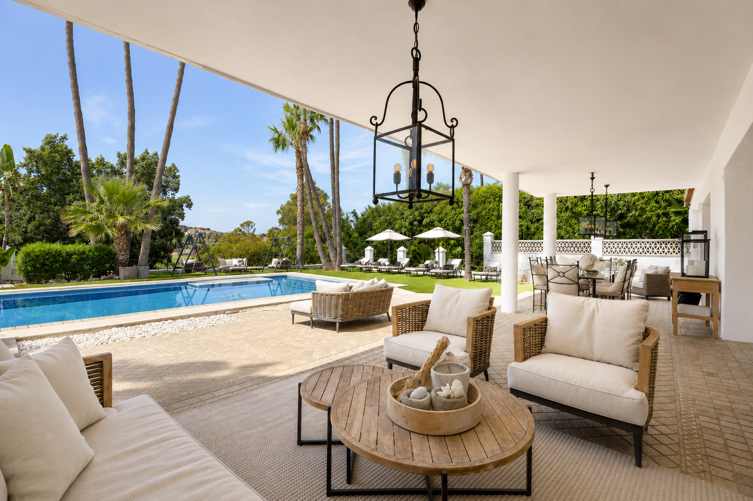 Covered patio with seating and dining area overlooking the pool.