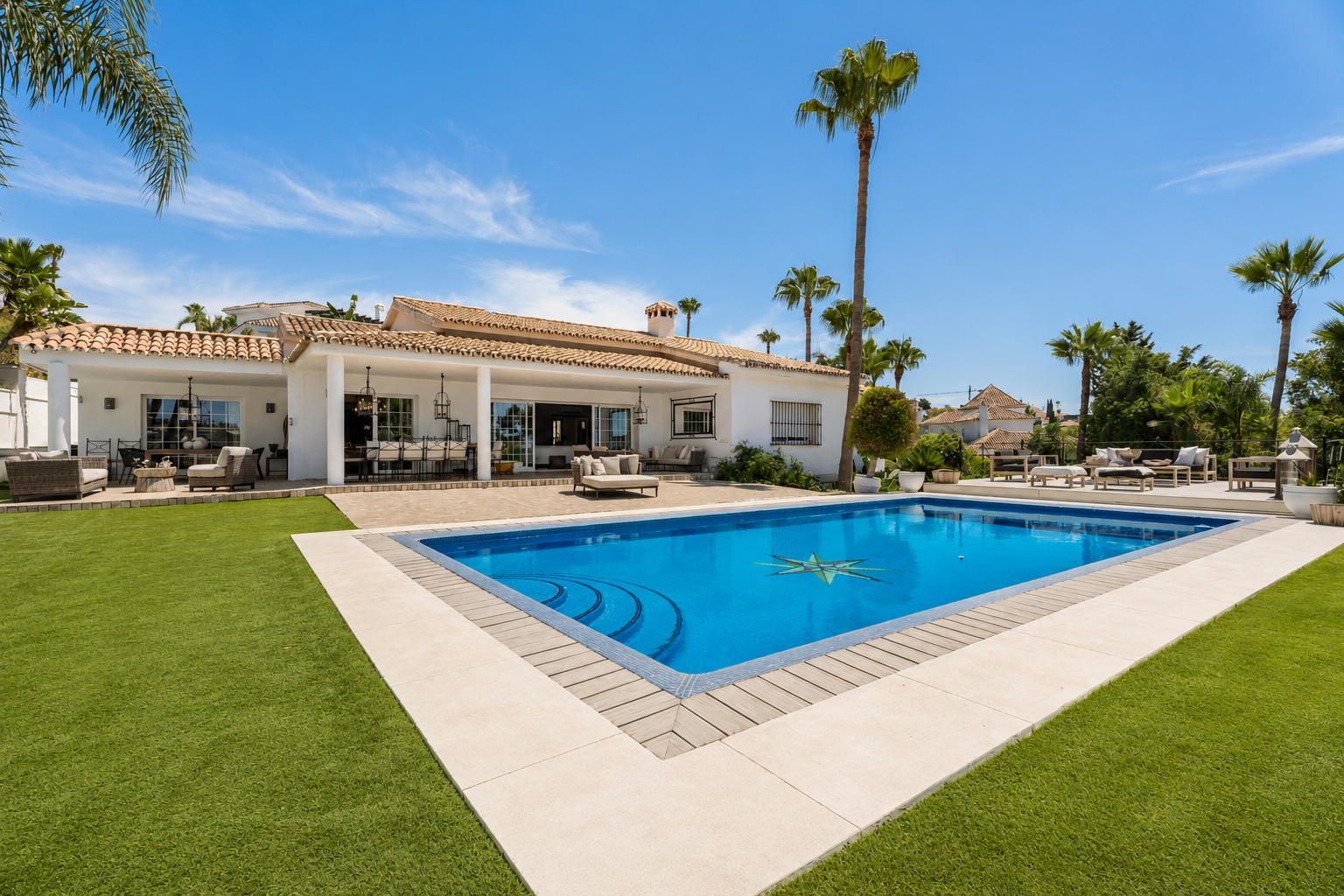Side view of the villa with swimming pool and palm trees in the background.