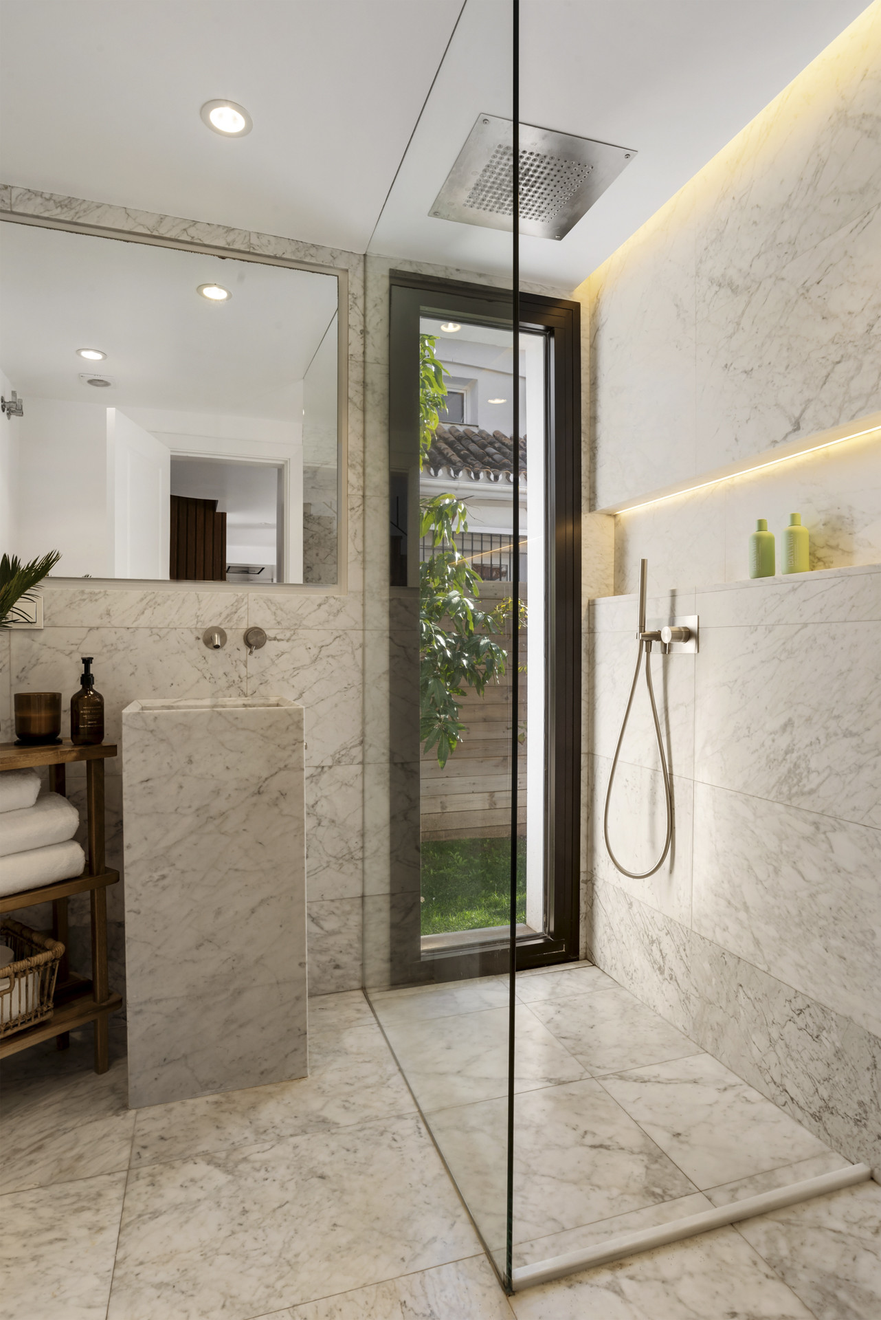 Spacious shower area featuring marble and a garden view.