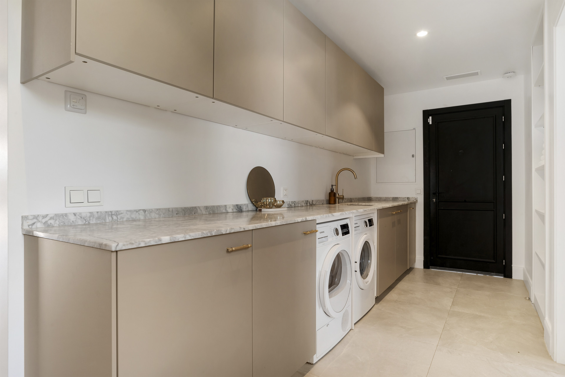 Laundry room with cabinetry, countertop, and washers side by side.