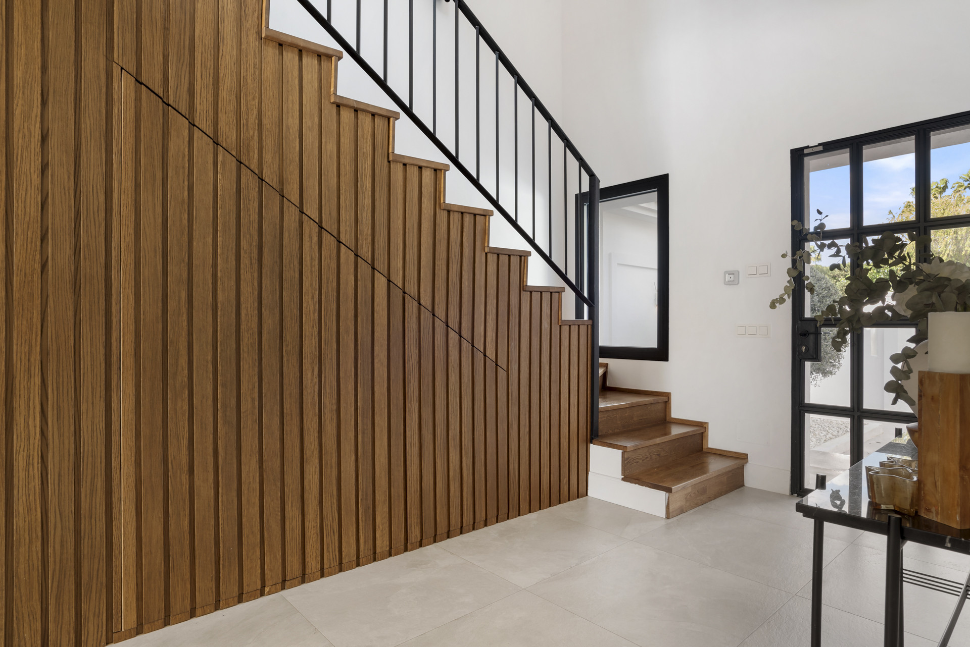 Staircase with wooden steps and vertical slat wall design.