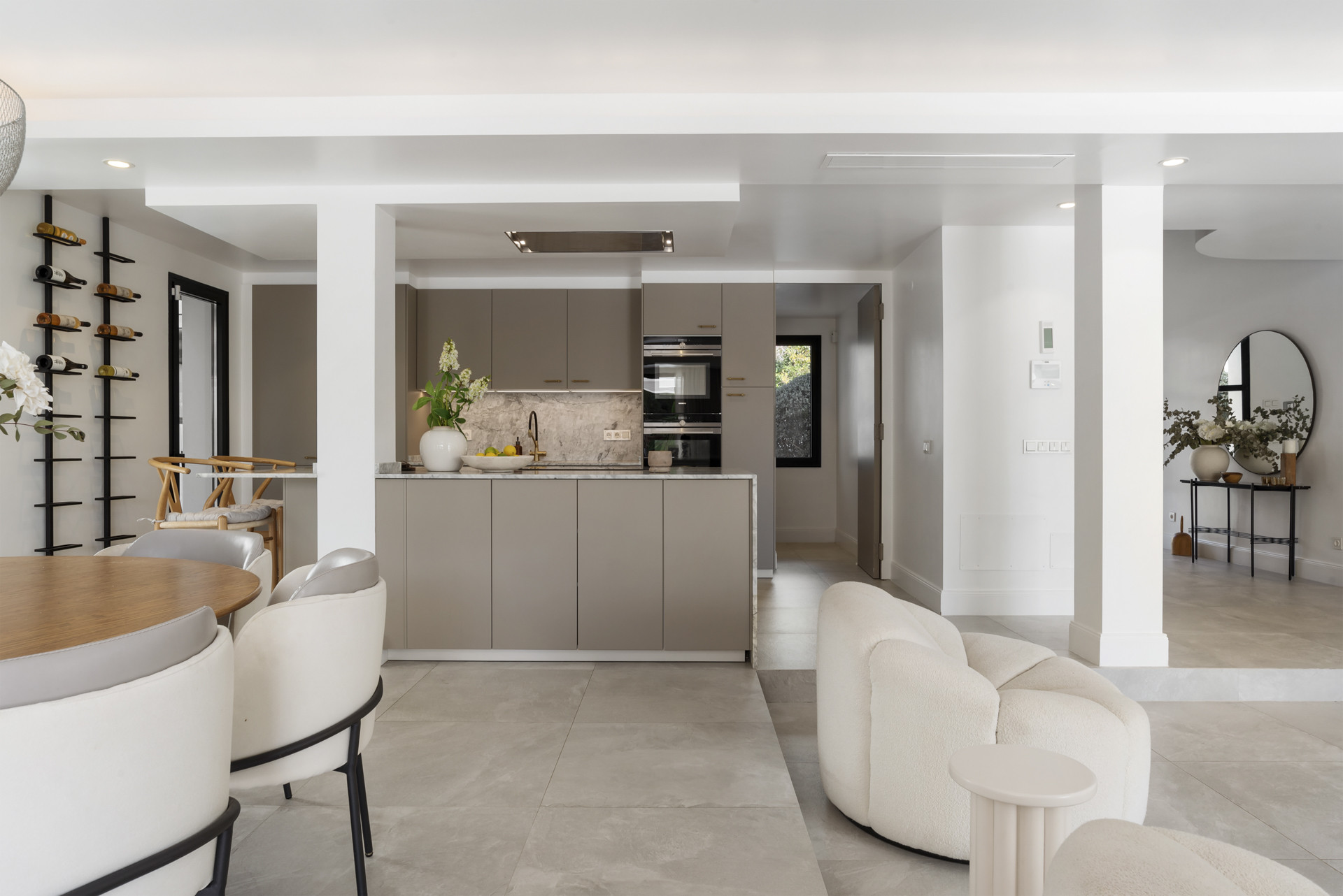 Open dining area adjacent to the kitchen with a round table and decorative elements.