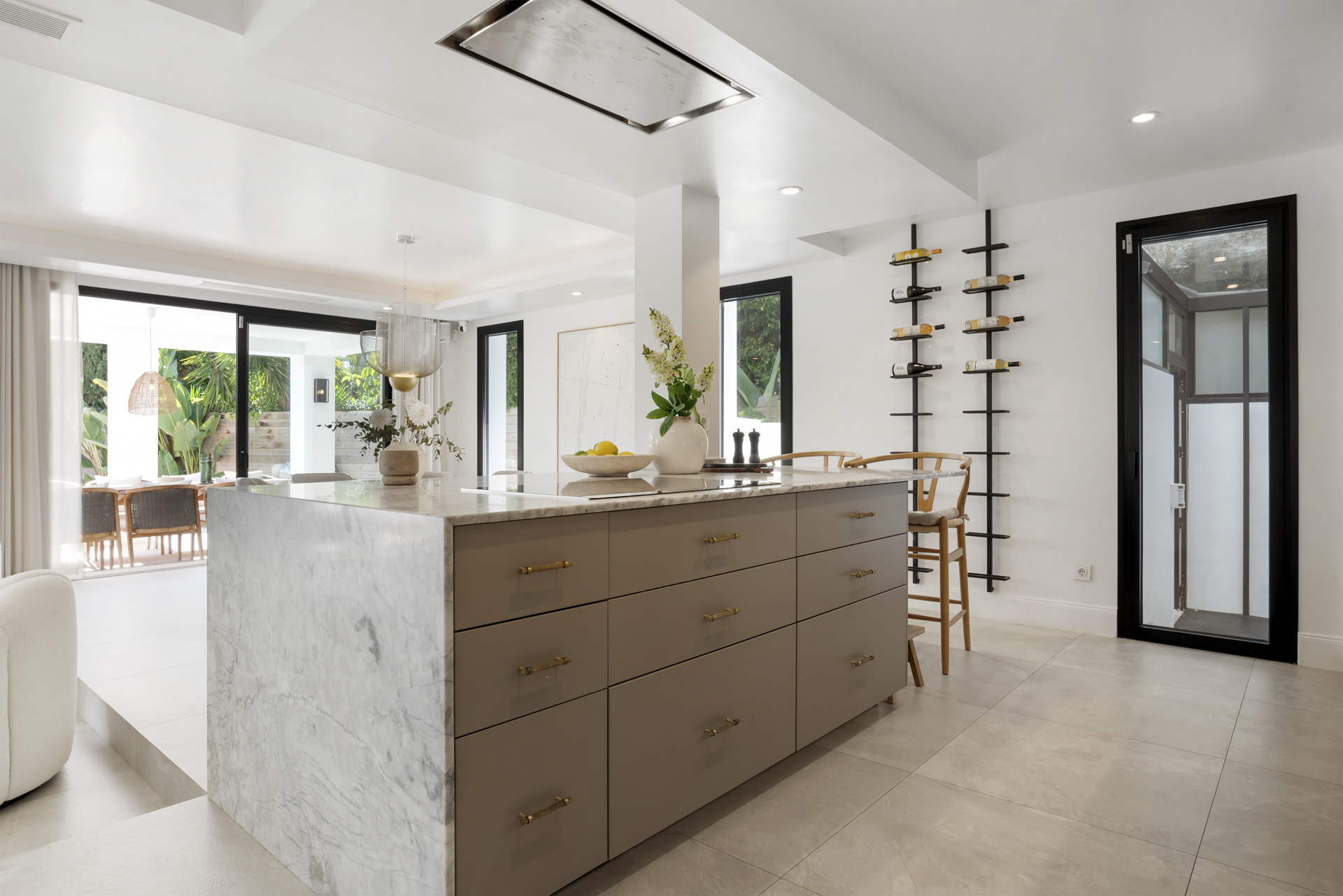 View into kitchen featuring a large island and windows leading to outdoor seating.