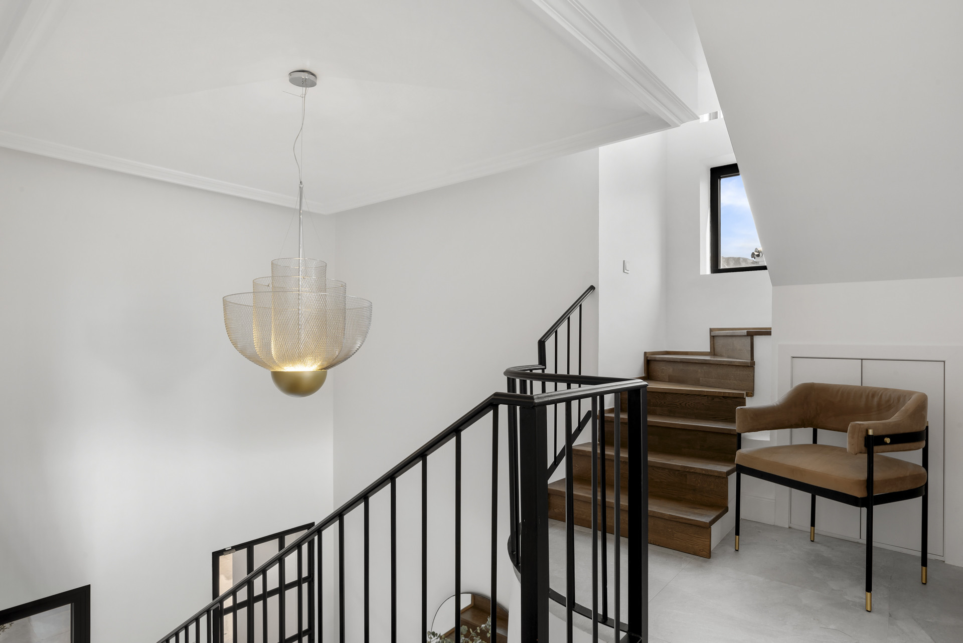 Staircase with a modern chandelier and beige steps