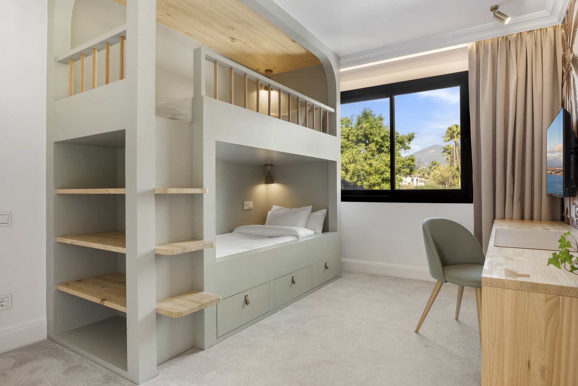 Stylish children's room with a loft bed, shelves, and a view through large window.