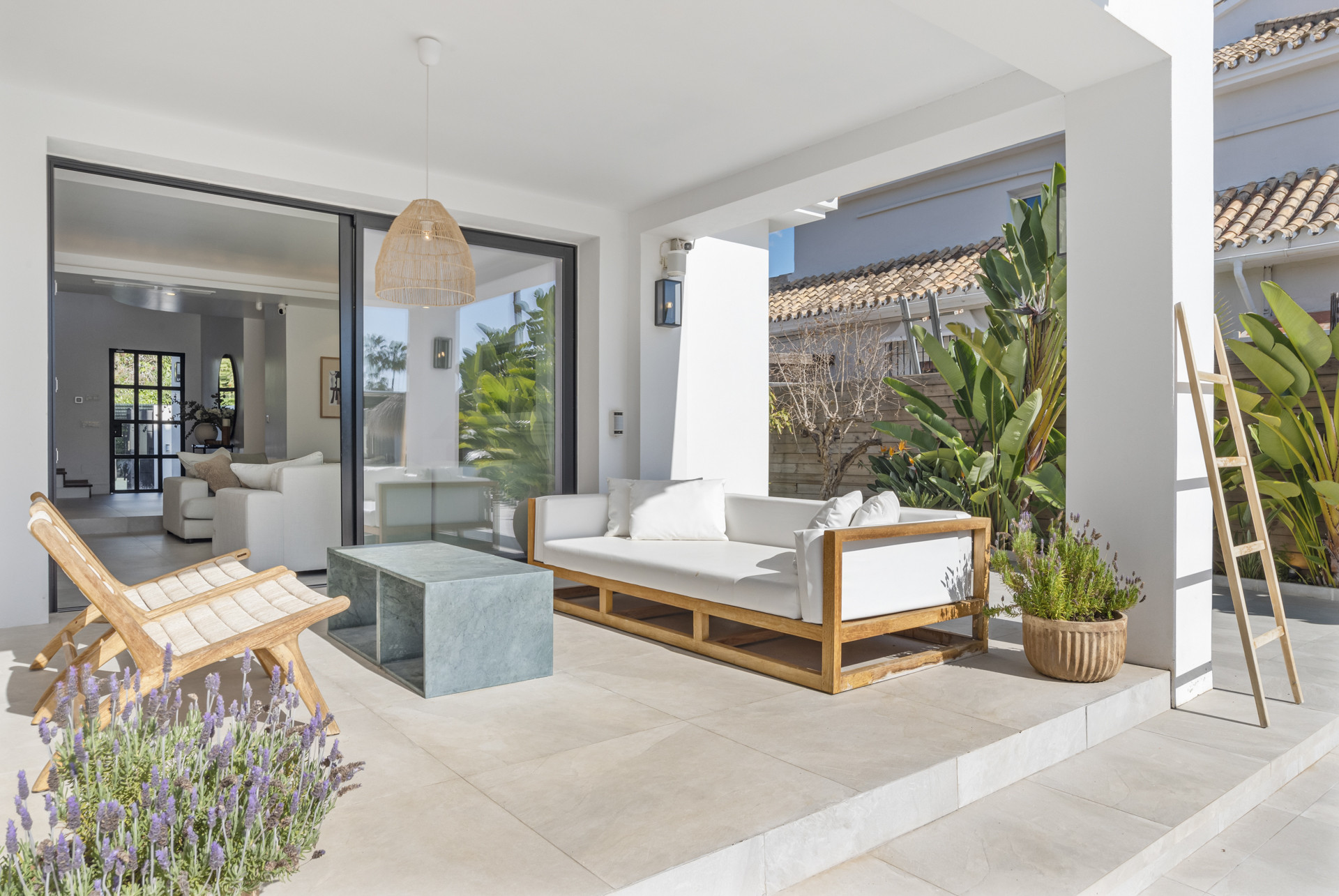 Outdoor seating area with clear view into the home and plants around.