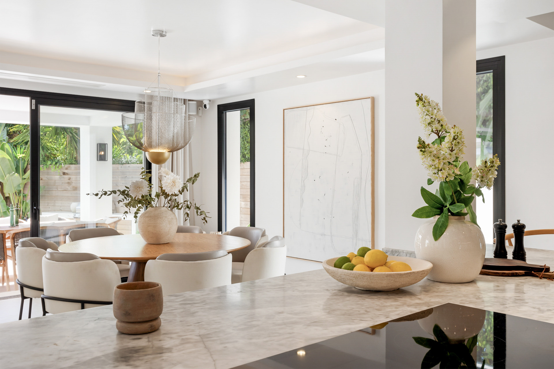Dining space highlighting a stylish light fixture and a contemporary round table.