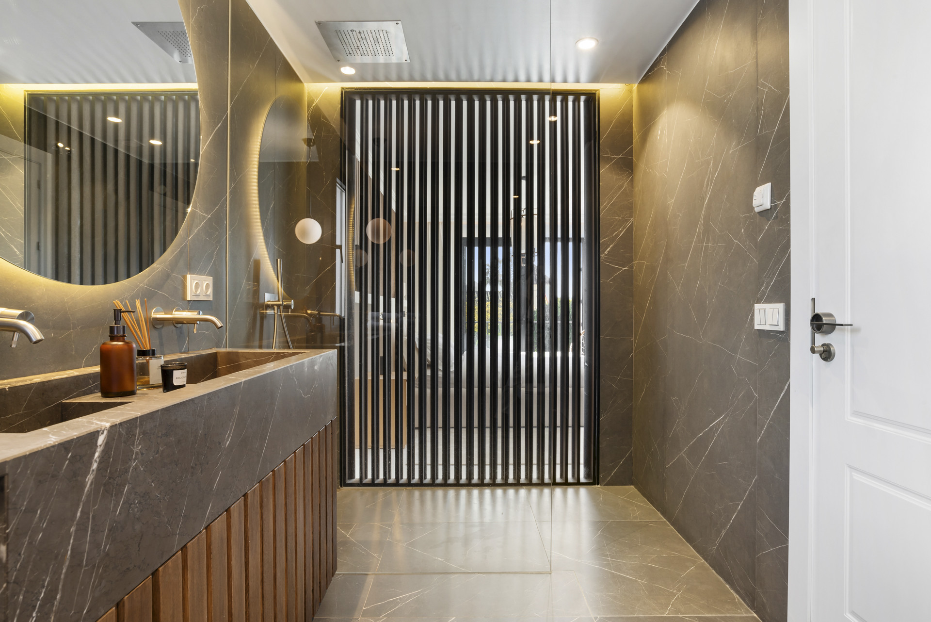 Chic bathroom with striped glass door, dual sinks, and ambient lighting.